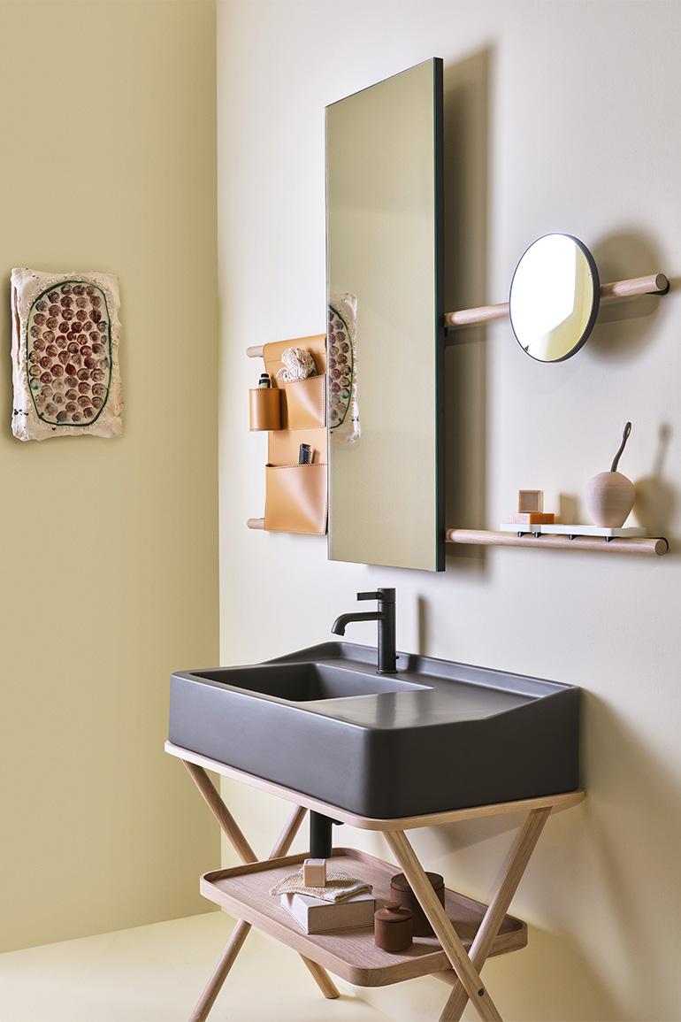 In this image, Siwa by Ceramica CIELO, designed by Andrea Parisio and Giuseppe Pezzano, the cabinet washbasin in the Fango finish of the “Terre di Cielo” colour range combined with a tray and wooden structure in the Natural Oak finish. On the wall a Siwa mirror in the rectangular version, with a wooden structure in the Natural Oak finish and a storage bag in natural leather.